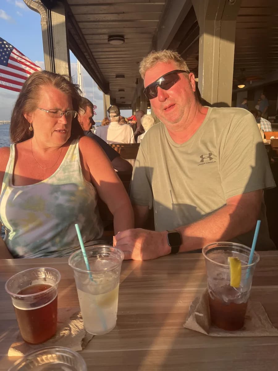 Michael and [wife's name] at a table, drinks in front of them