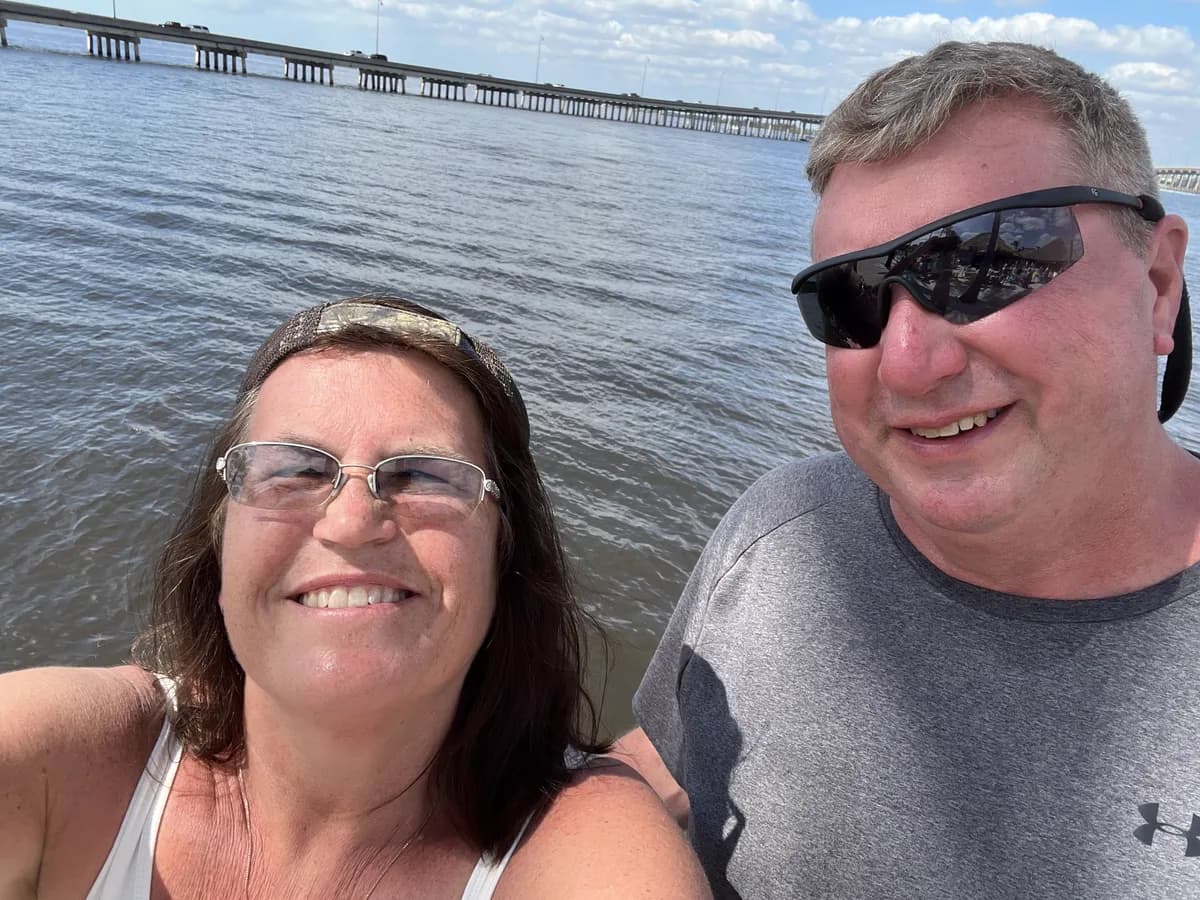 Michael and [wife's name] by the water on a bright day