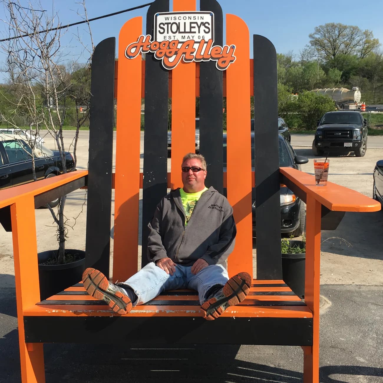 Michael sitting in an enormous orange Adirondack chair in Wisconsin