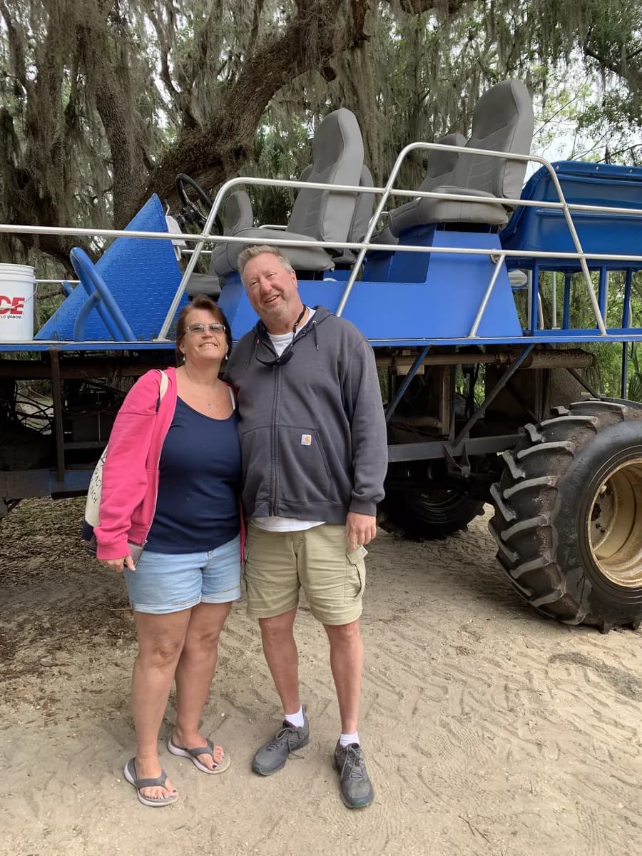 Michael and [wife's name] standing in front of a monster truck